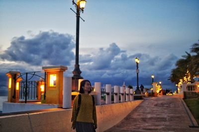 Illuminated street light against sky at dusk