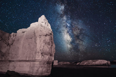 Rock formation against sky at night