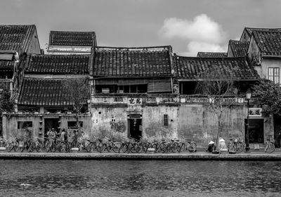 Riverside houses against sky