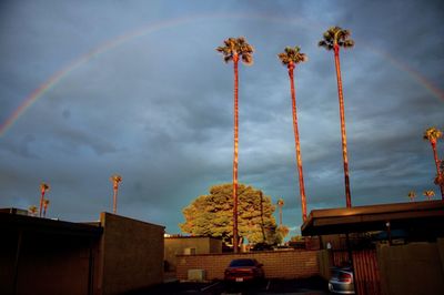 Low angle view of rainbow over building against sky