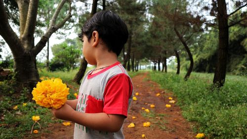 Boy standing by flower tree