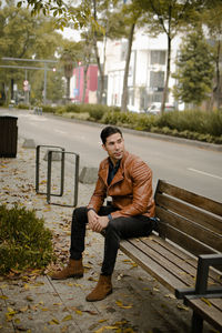 Full length of young man sitting on bench