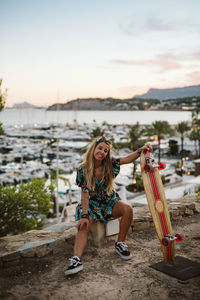 Full length portrait of woman against sky during sunset