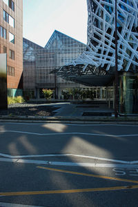 Road by buildings against sky in city