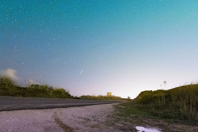 Scenic view of road against clear sky at night