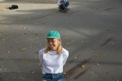 A young woman sitting down on concrete