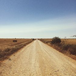 Empty road amidst landscape against sky