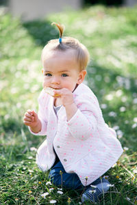 Portrait of cute baby girl on field