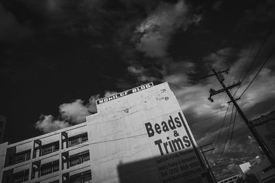 Low angle view of text on building against sky