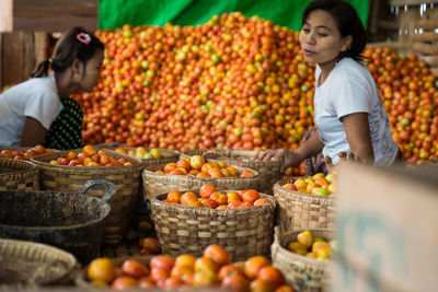 Full length of friends at market stall