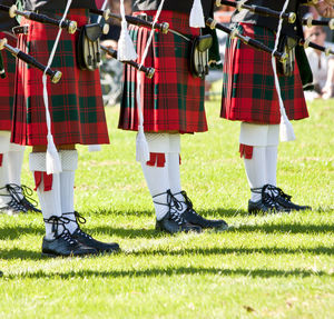 People in kilt standing on grassy field