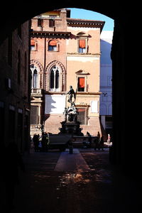 Statue in alley amidst buildings in city