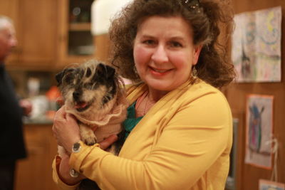 Portrait of smiling woman with dog at home