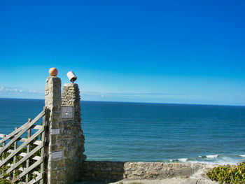 Man looking at sea against blue sky