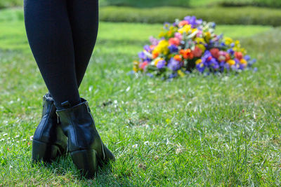 Low section of woman standing on flowering plants