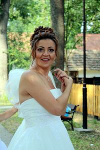 Portrait of smiling bride standing outdoors