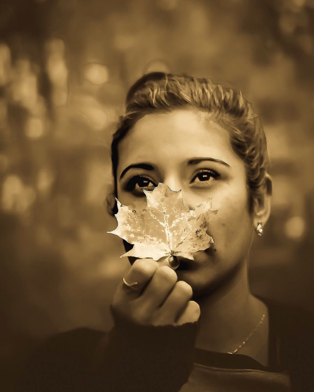 CLOSE-UP PORTRAIT OF YOUNG WOMAN HOLDING CAMERA