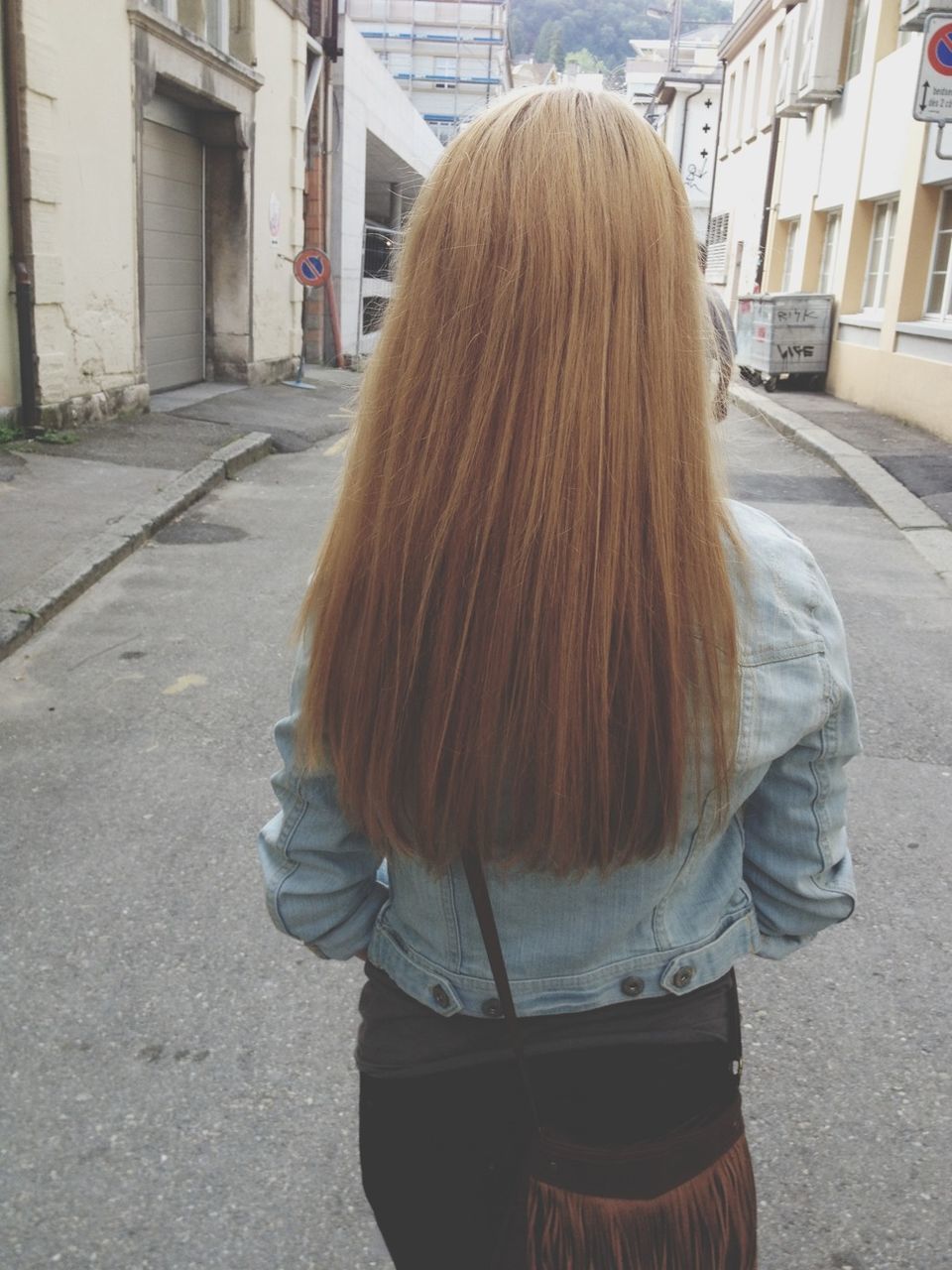 rear view, lifestyles, street, building exterior, casual clothing, architecture, built structure, person, long hair, leisure activity, standing, walking, city, brown hair, day, side view, road, full length