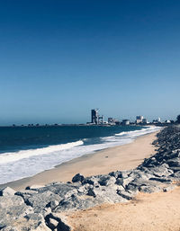 Scenic view of beach against clear blue sky