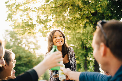 Young female with drink standing while toasting in social gathering