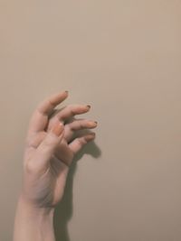 Close-up of woman hand against wall