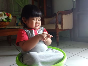 Cute girl sitting on floor at home