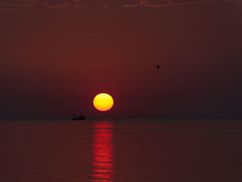 Scenic view of sea against orange sky