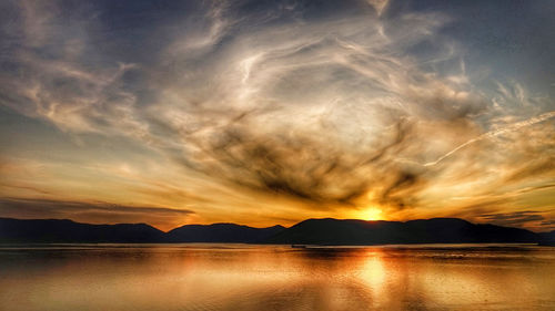 Scenic view of dramatic sky over sea during sunset