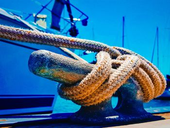 Close-up of rope tied to boat moored at harbor