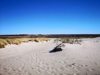 Scenic view of desert against clear blue sky