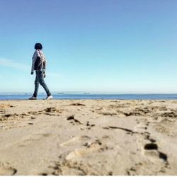 Full length of man standing on beach against clear sky