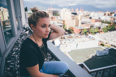 Portrait of woman sitting in city