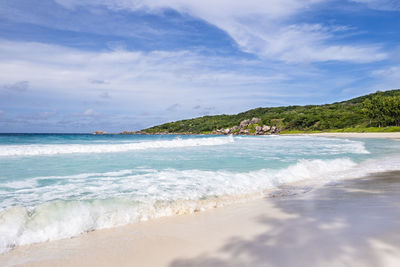 Blue lagoon and white sand on sunny summer day, on  tropical beach, la digue island, seychelles.