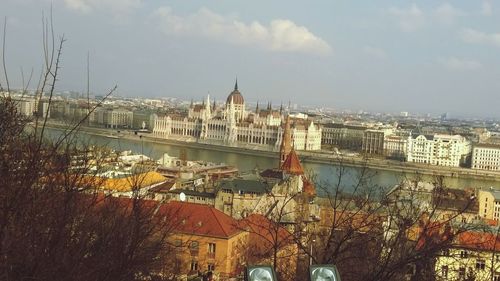 View of cityscape against cloudy sky