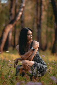 Portrait of young woman sitting in forest