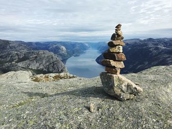 Stack of stones on rock against sky