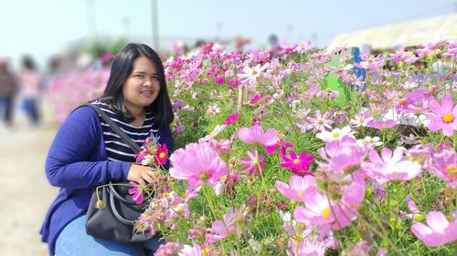 Portrait of young woman picking flowers