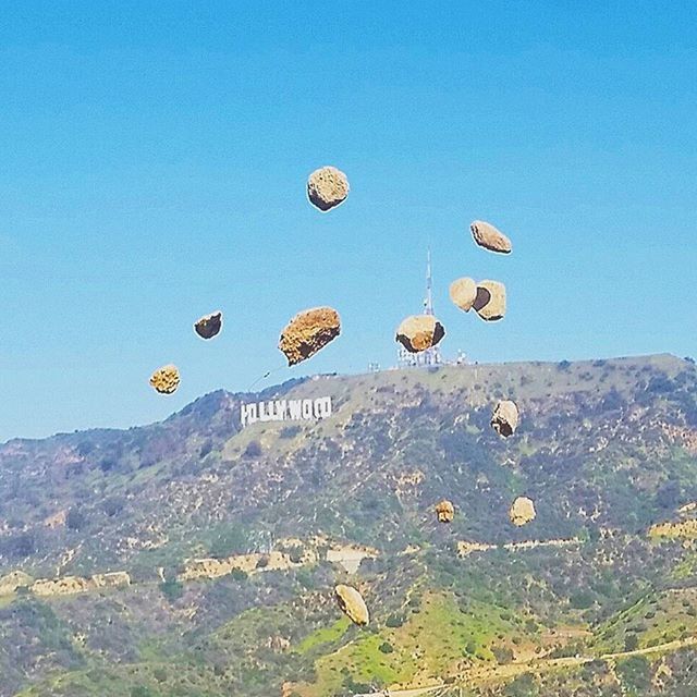 clear sky, blue, copy space, landscape, tranquility, tranquil scene, nature, scenics, low angle view, mid-air, beauty in nature, sky, day, hot air balloon, mountain, outdoors, non-urban scene, circle, no people, rock - object