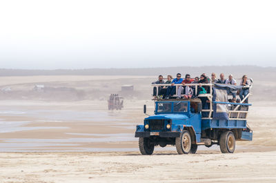 Group of people on road against clear sky