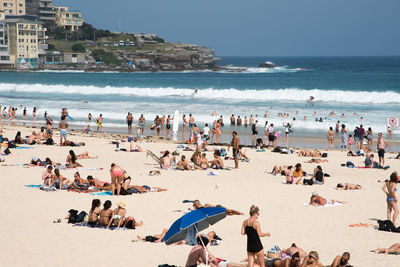 Crowd at beach against sky