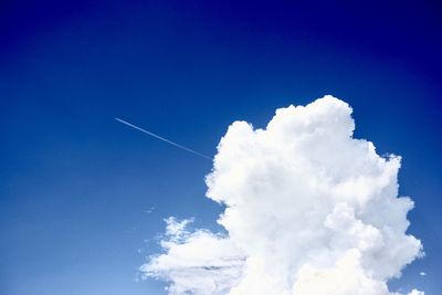 Low angle view of vapor trail against blue sky