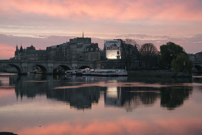 Reflection of buildings in river at sunset