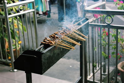 High angle view of satay cooking on barbeque at market stall