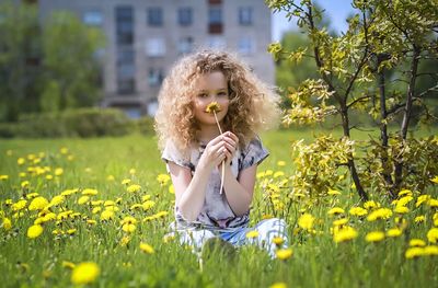 Young woman with yellow flower in field