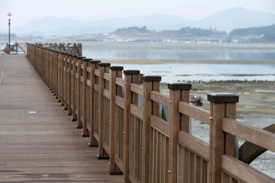 Empty pier over sea against sky