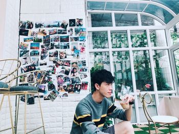 Young man looking through window