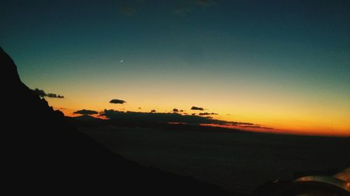 Scenic view of silhouette beach against clear sky at sunset