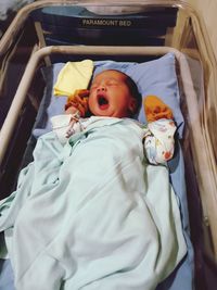 High angle view of baby boy sleeping on bed