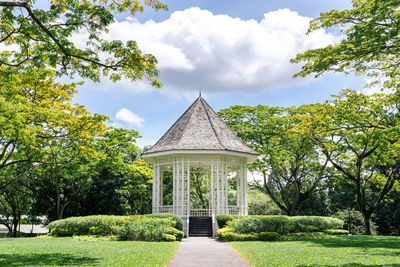 The bandstand in botanic gardens, singapore, surrounded by terraced flower beds and palms.