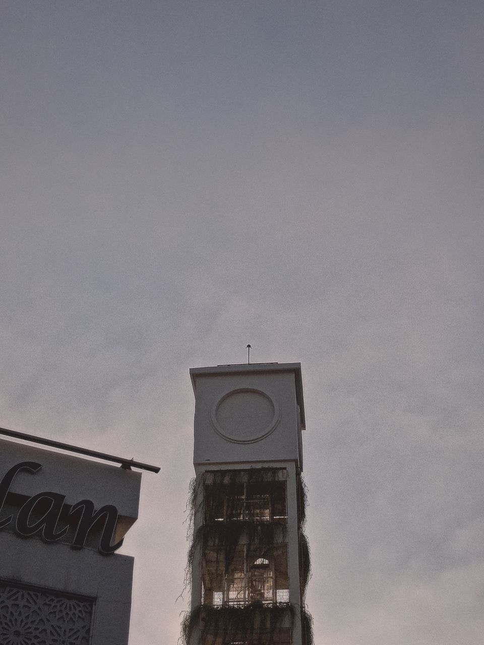 LOW ANGLE VIEW OF CLOCK TOWER AGAINST BUILDING